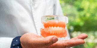specjalista trzymający protezę zębową
